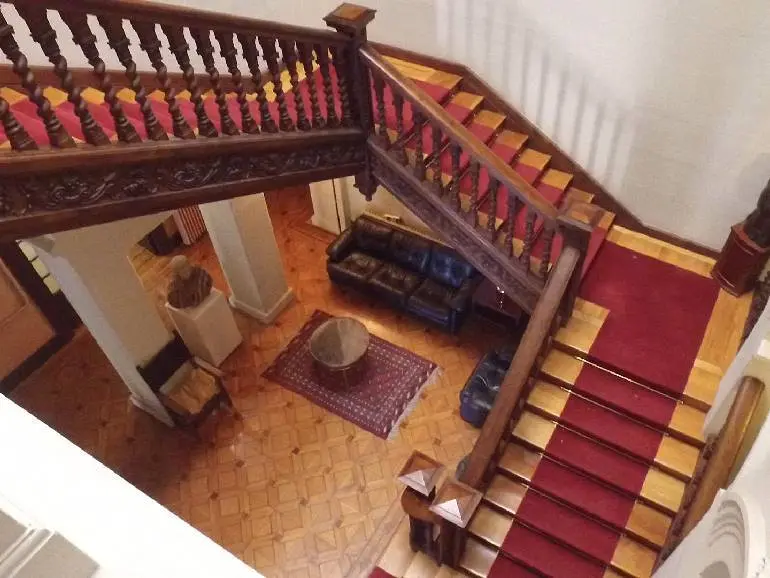 La escalera en tres tramos de madera tallada es uno de los grandes atractivos de la villa