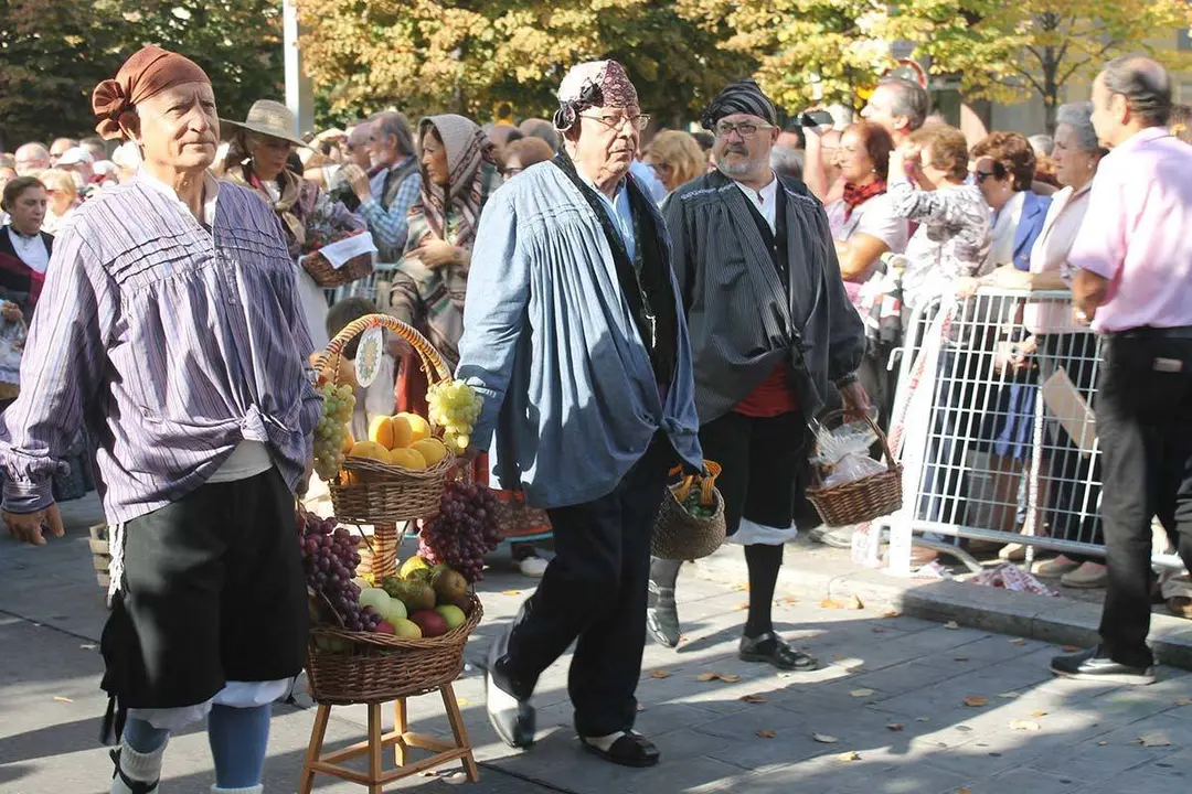 Varios oferentes llevan una cesta de fruta a la Virgen del Pilar