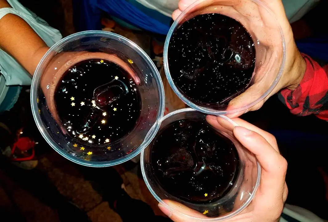 Tres manos sujetan vasos de pl&aacute;stico