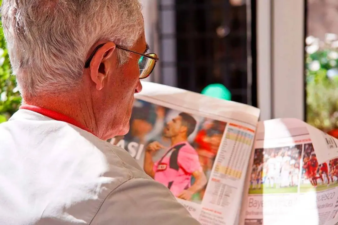 Persona mayor leyendo un peri&oacute;dico