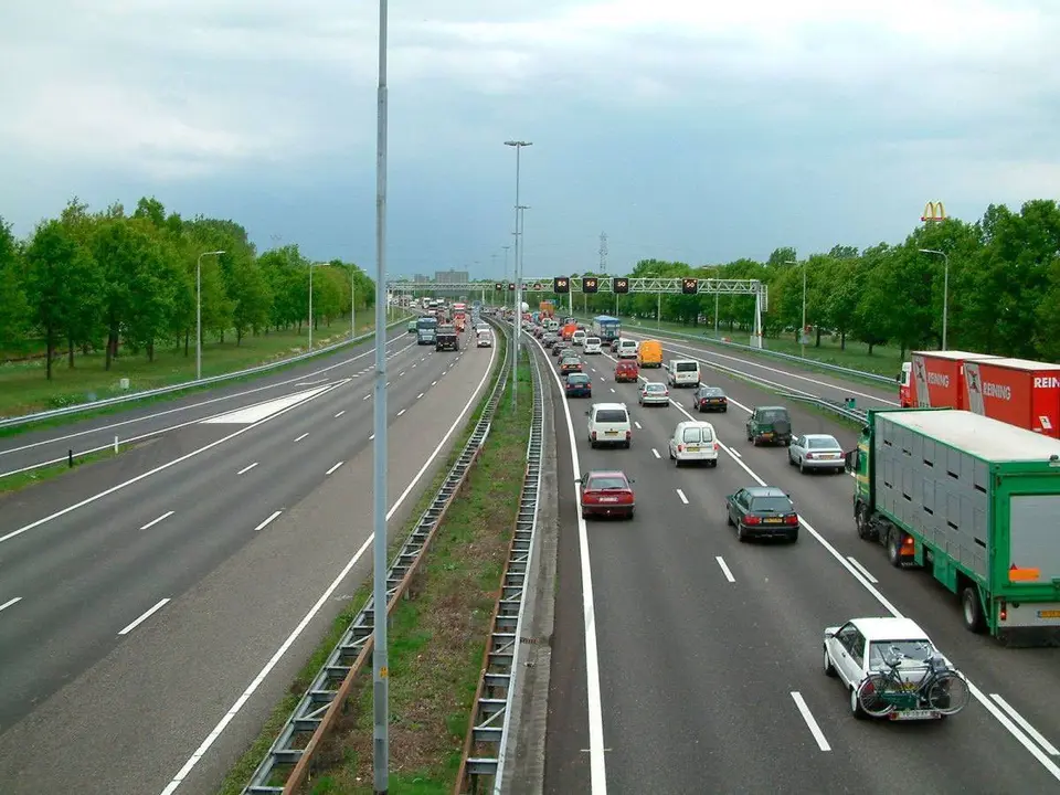 Carretera de cuatro carriles con coches circulando en direcci&oacute;n salida