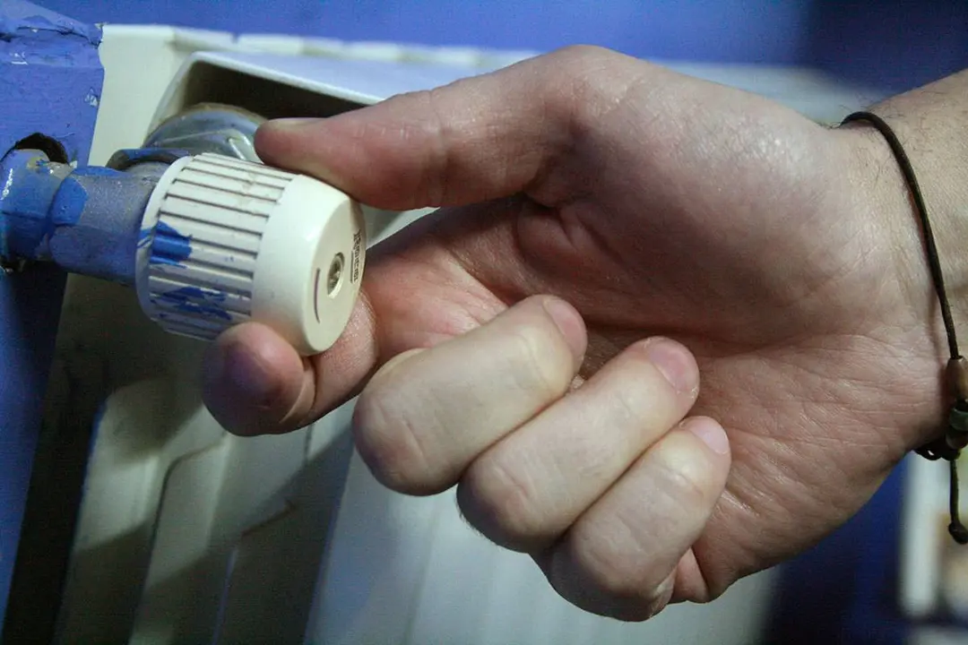 Una mano ajusta un radiador