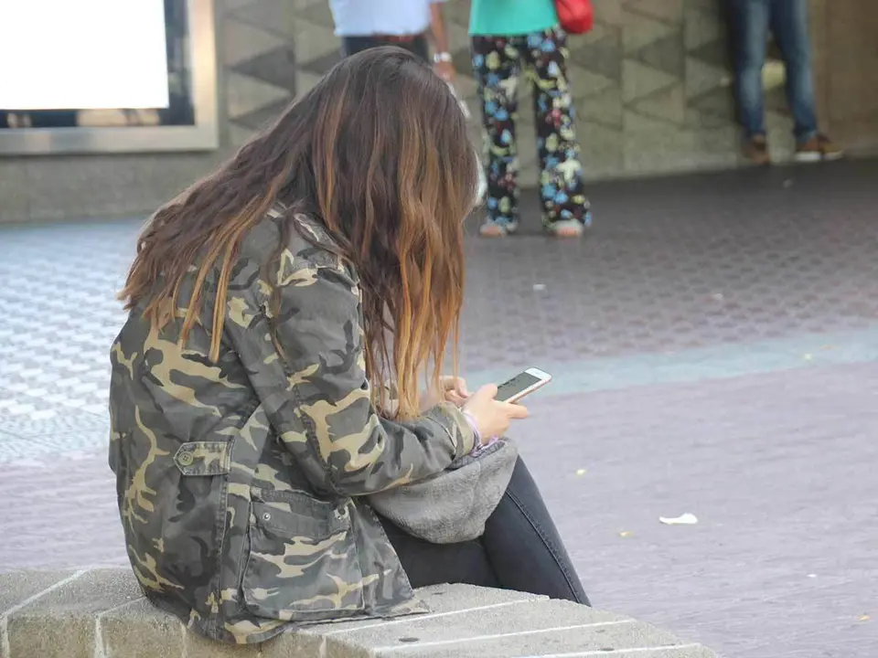 Chica sentada con su movil
