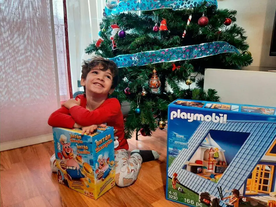 Un ni&ntilde;o sonr&iacute;e con sus regalos de Reyes Magos