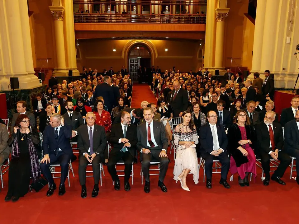 Imagen de los reyes y autoridades con los premiados de fondo