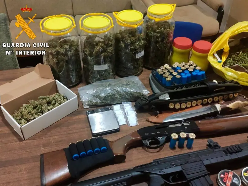 Mesa con marihuana, armas y los efectos encontrados en la casa