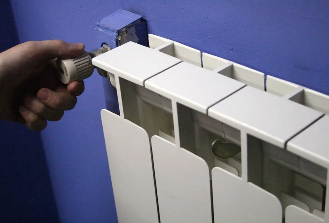 Una mano manipulando un radiador