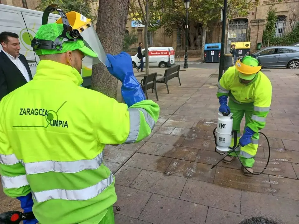Los operarios limpian unas pintadas en el pavimento