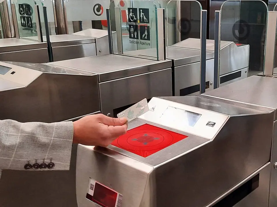 Mano que acerca tu tarjeta de cr&eacute;dito al torno de Renfe