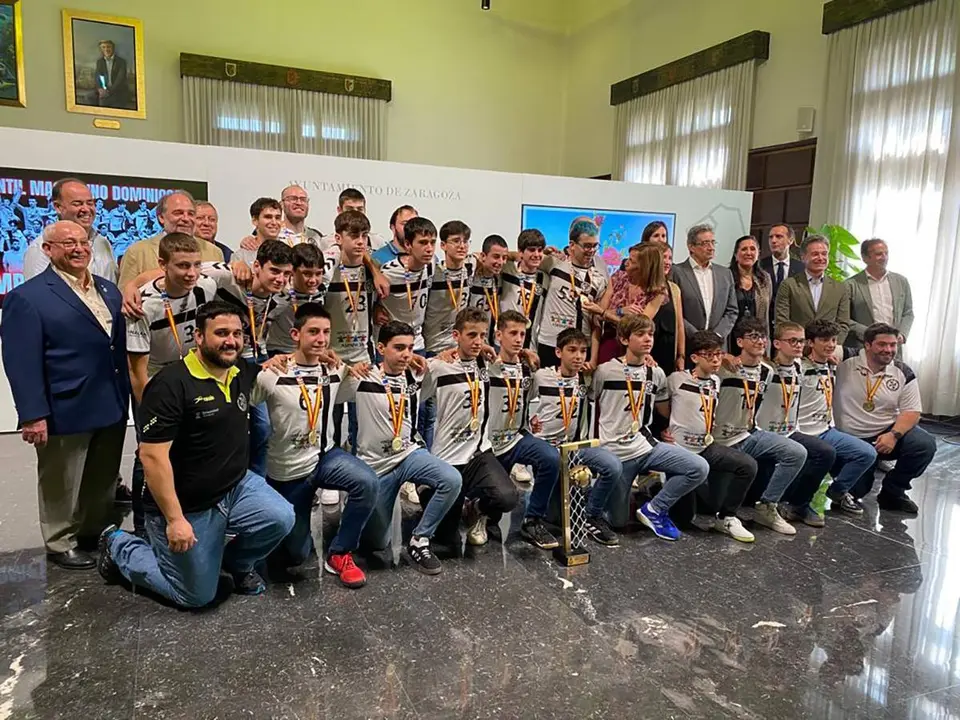 Foto de familia del Balonmano Dominicos junto al trofeo y a las distintas autoridades y staff del equipo.