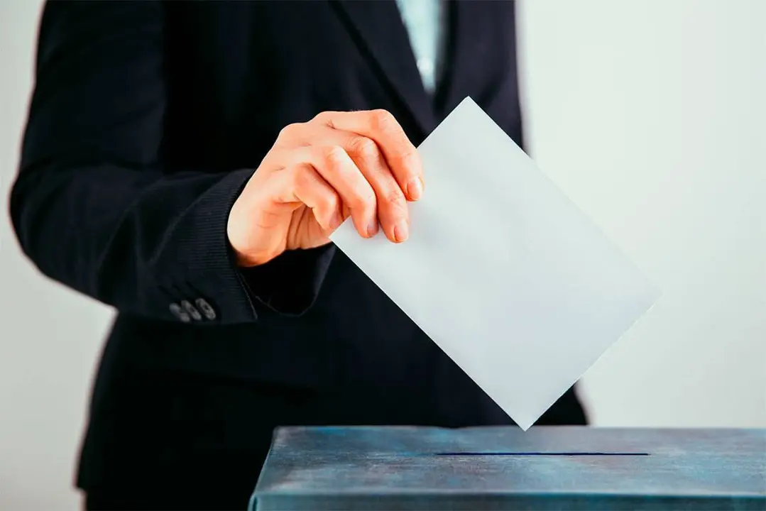 Un hombre depositando un voto en una urna