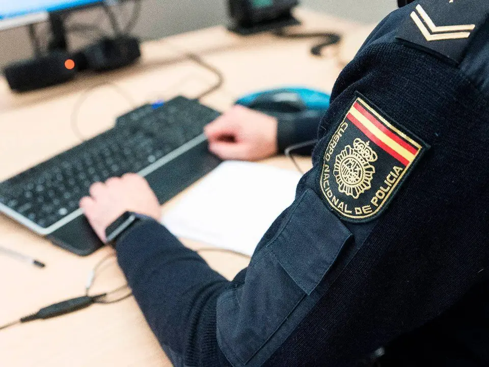 Polic&iacute;a con un teclado y un ordenador 