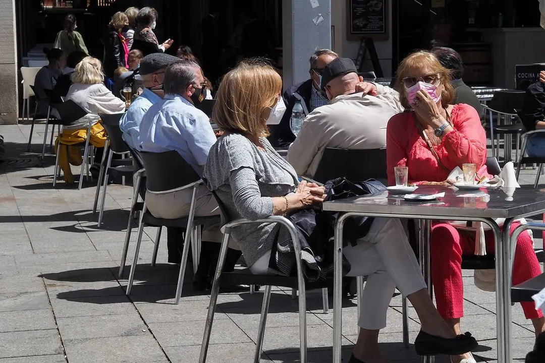 Dos se&ntilde;oras en una terraza con mascarillas por covid