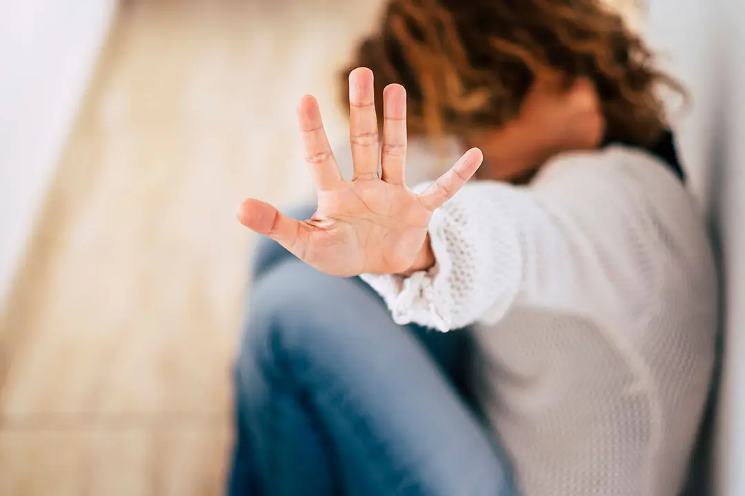 Una mujer esconde su rostro tras ser agredida