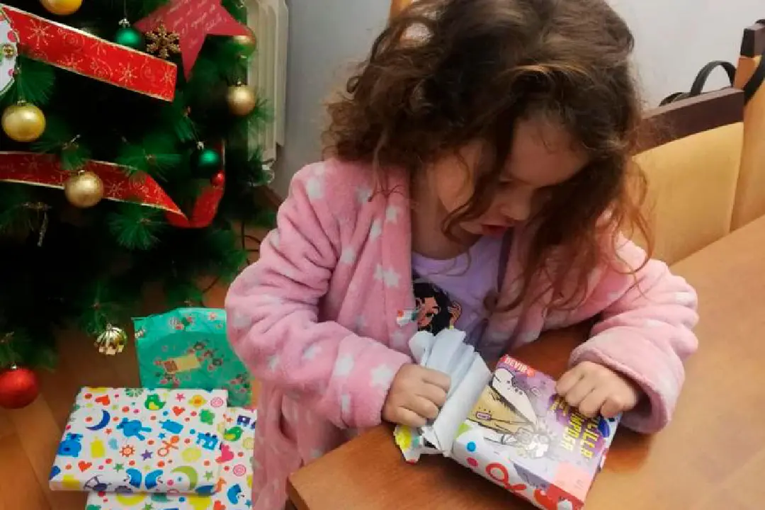 ni&ntilde;a abre los regalos de los reyes magos 