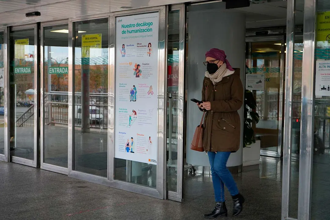 Una persona sale de un centro hospitalario con mascarill