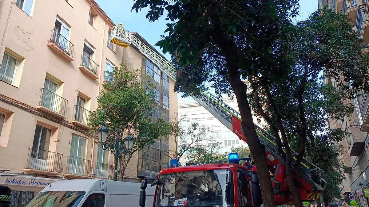 El veh&iacute;culo autoescala de 30 metros de Bomberos Zaragoza retirando cascotes en uno de los edificios de la calle Don Jaime
