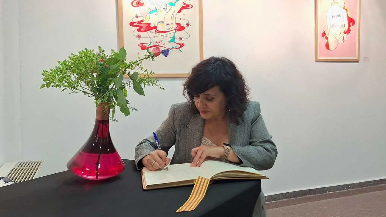 Secretaria firma el libro de honor
