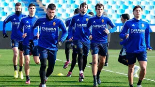 Varios jugadores realizan carrera continua en el c&eacute;sped de La Romareda