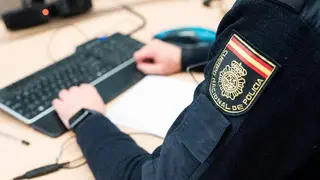Polic&iacute;a con un teclado y un ordenador 