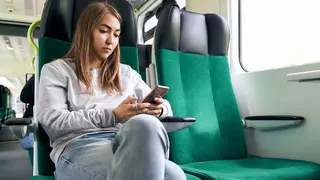 mujer con el m&oacute;vil en el tren operaci&oacute;n salida