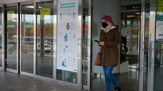 Una persona sale de un centro hospitalario con mascarill