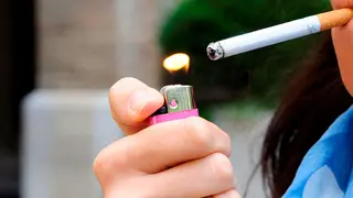 Imagen de archivo de una mujer encendiendo un cigarro