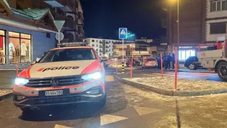 Una patrulla policial vigila el per&iacute;metro de seguridad frente al establecimiento en el que tuvo lugar el incendio | Foto de Police Cantonale du Valais