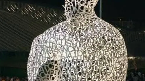Unos visitantes observan el "Alma del Ebro" que, agarrada a sus rodillas, parece pensativa. Pero... &iquest;por qu&eacute; derroteros viajar&aacute;n sus ideas?
Por Gonzalo Baz&aacute;n y Pilar Artiaga