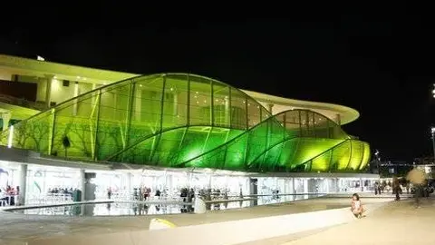 El Pabell&oacute;n de Am&eacute;rica Latina cambia espectacularmente de imagen del d&iacute;a a la noche. Un verde &aacute;cido, casi fluorescente, anima el exterior de este edificio.
Por Gonzalo Baz&aacute;n y Pilar Artiaga