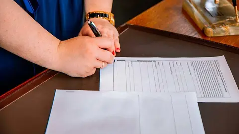 Mujer firmando documentos laborales 
