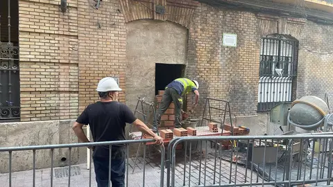 Operarios tapian un edificio ocupado en la calle Pignatelli