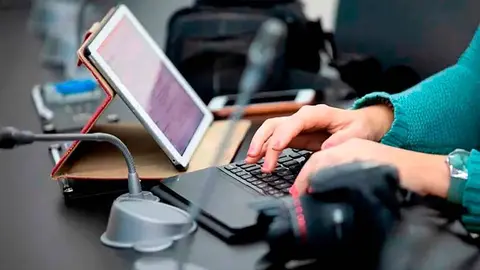 Manos de mujer sobre teclado de ordenador