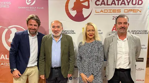 Varias personas delante del cartel del torneo de golf