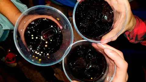 Tres manos sujetan vasos de pl&aacute;stico
