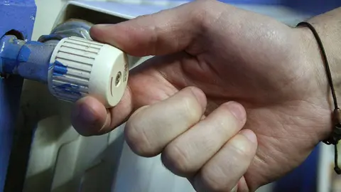 Una mano ajusta un radiador