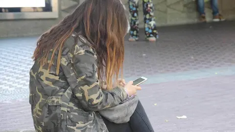 Chica sentada con su movil