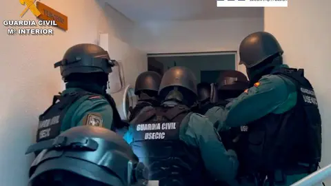 Agentes de la Guardia Civil irrumpen en una casa para registrarla