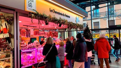 Varias personas esperan su turno en un puesto del Mercado Central 