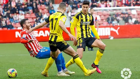 Nieto pelea por el bal&oacute;n con un jugador del Sporting que cae al suelo