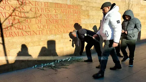 Varias personas dejan una flor blanca en homenaje a las v&iacute;ctimas