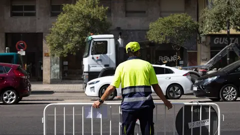 Trabajador cortando una calle con una valla 