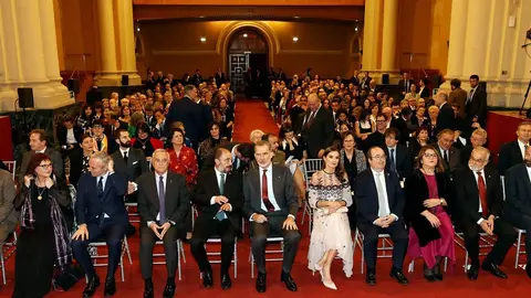 Imagen de los reyes y autoridades con los premiados de fondo