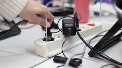 una persona conecta enchufe a la electricidad