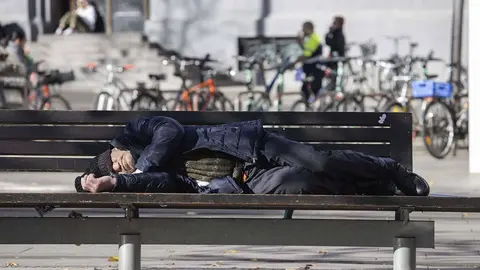 Persona durmiendo en un banco