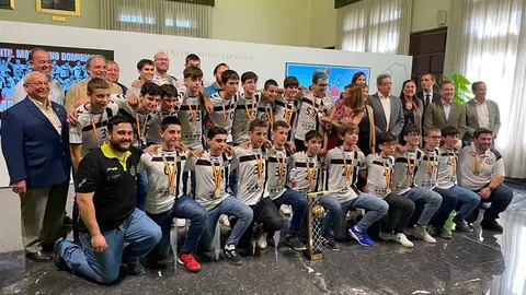 Foto de familia del Balonmano Dominicos junto al trofeo y a las distintas autoridades y staff del equipo.