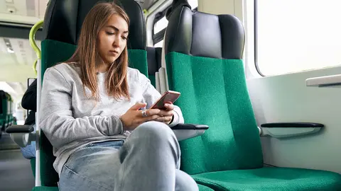 mujer con el m&oacute;vil en el tren operaci&oacute;n salida