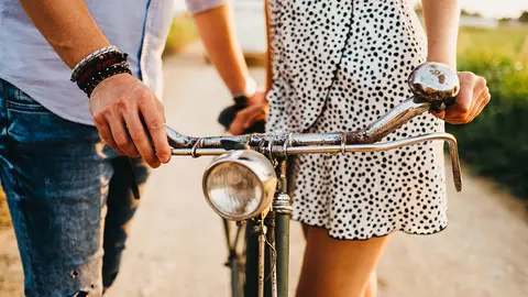 Pareja con bicicleta en carretera rural