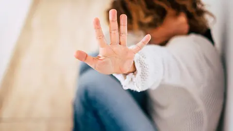 Una mujer esconde su rostro tras ser agredida