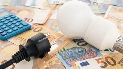 Euros junto a un enchufe y una bombilla